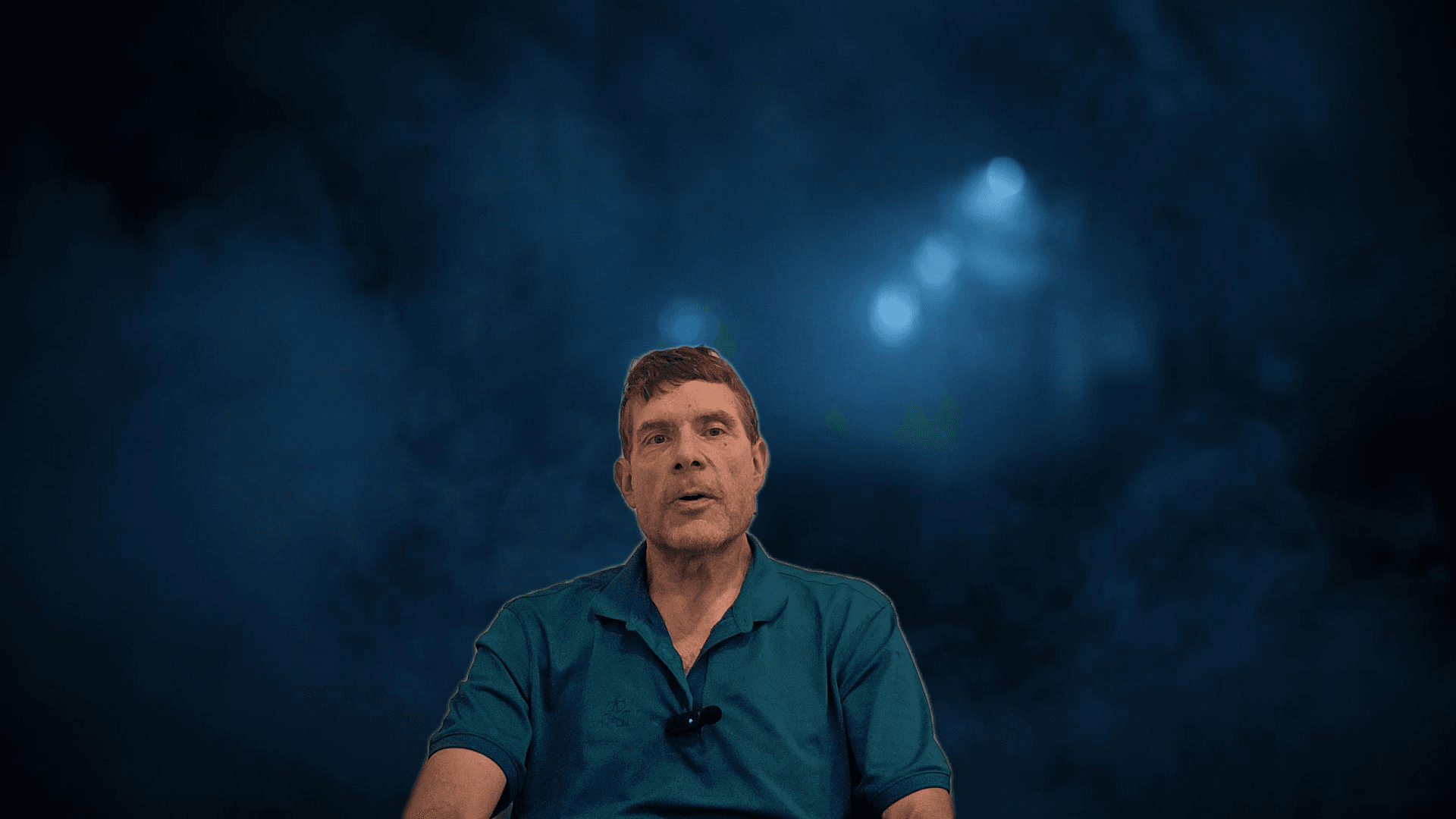 David speaking directly to camera about his CBD and Parkinson’s experience in the companion video, wearing a teal polo shirt with a lapel microphone.